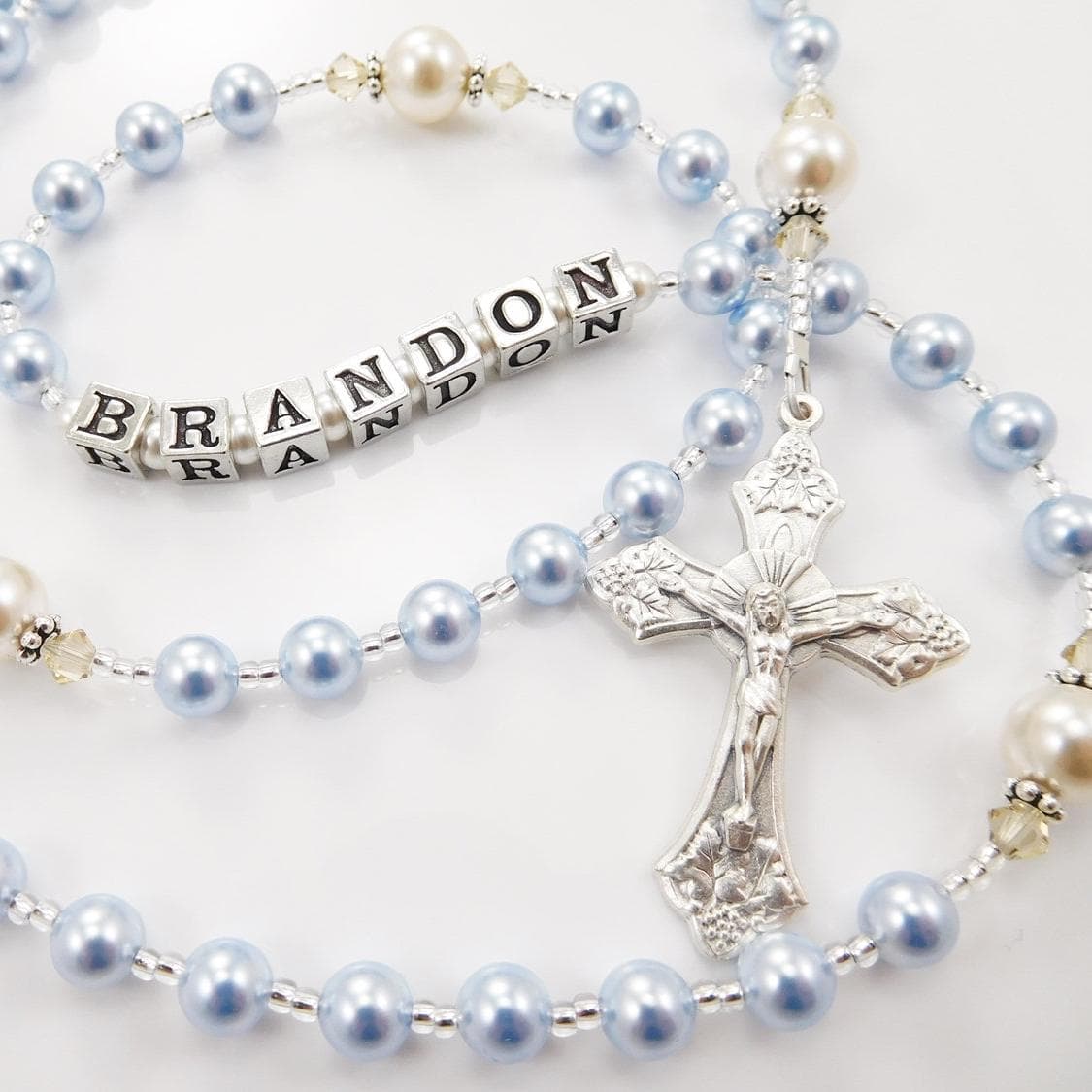 Light blue and cream rosary beads, personalized with a name or initials. Handmade in the USA. Sterling silver components. Choose from 15 Italian crucifix and center medals. Makes a perfect baptism gift for a baby boy or girl. First Communion