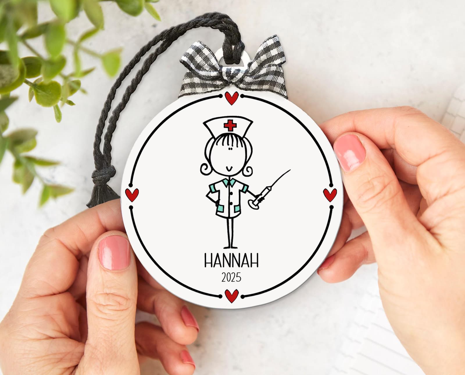 Custom Nursing ornament with whimsical drawing & name and date. White flat round 3" ornament with black lettering and red hearts, checked bow & string hanging cord. Whimsical design, personalized nurse thank you keepsake gift!