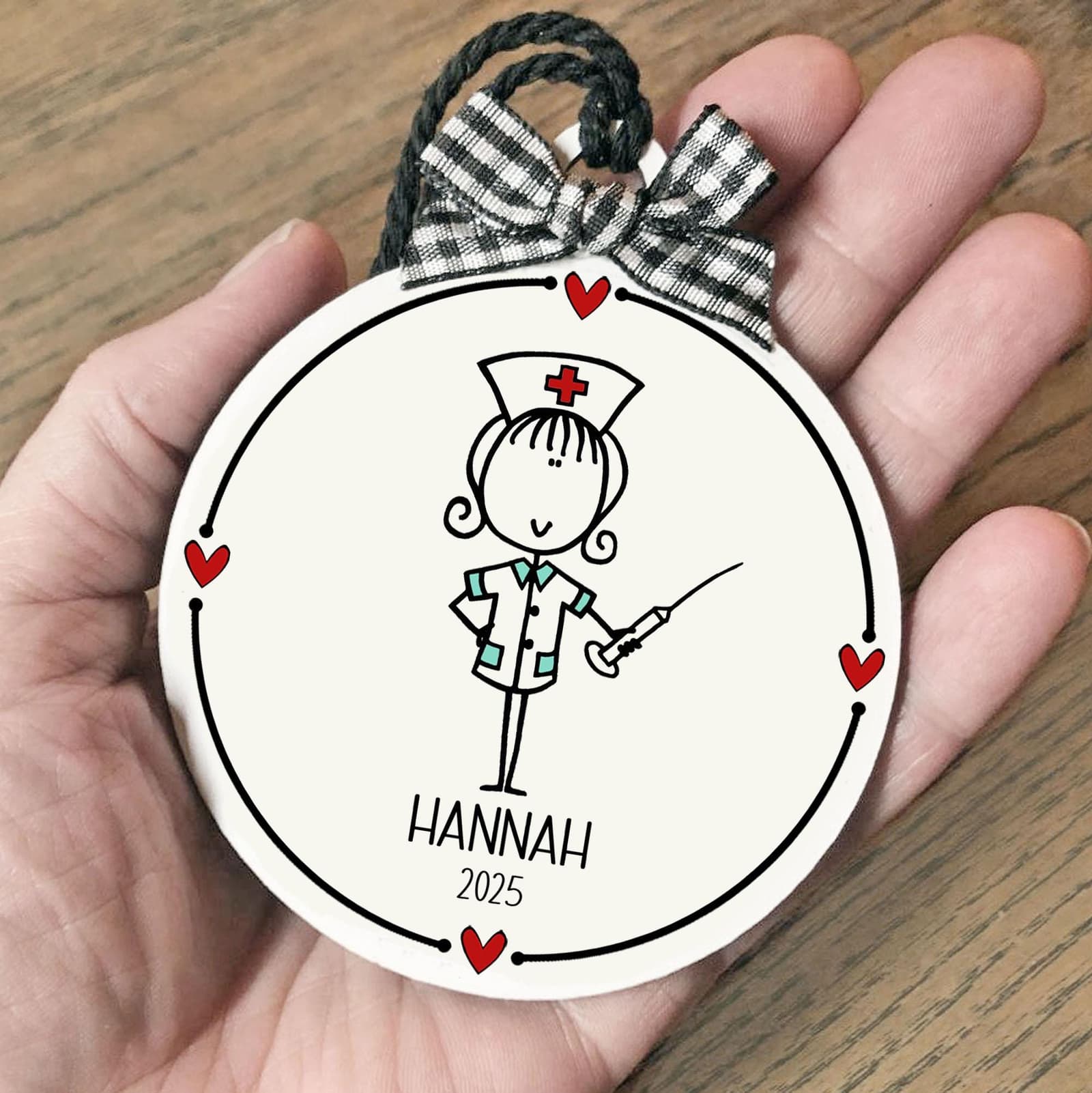 Custom Nursing ornament with whimsical drawing & name and date. White flat round 3" ornament with black lettering and red hearts, checked bow & string hanging cord. Whimsical design, personalized nurse thank you keepsake gift!