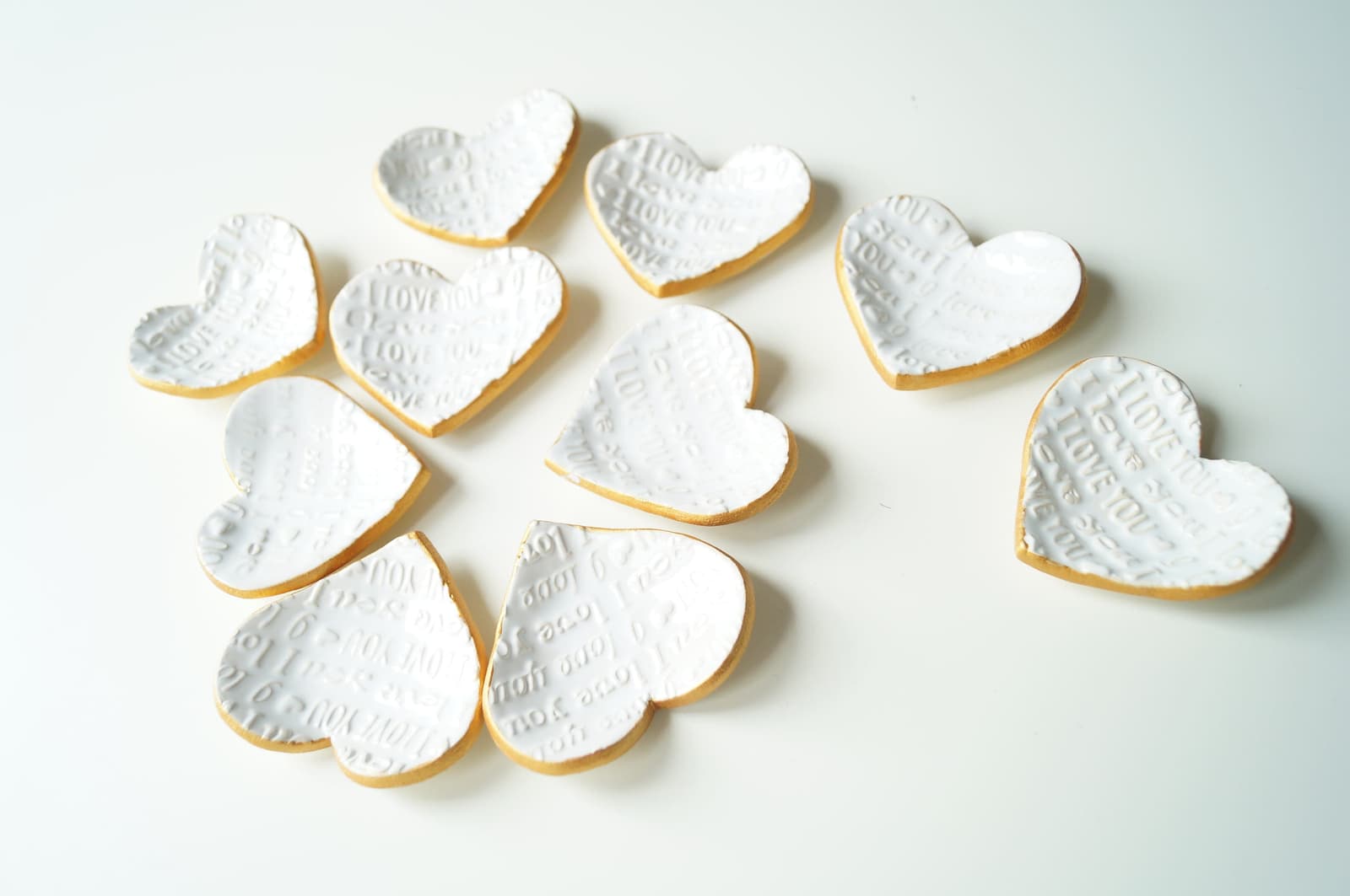 Varios platitos de corazón de cerámica hechos a mano, mostrando ligeras variaciones entre unidades