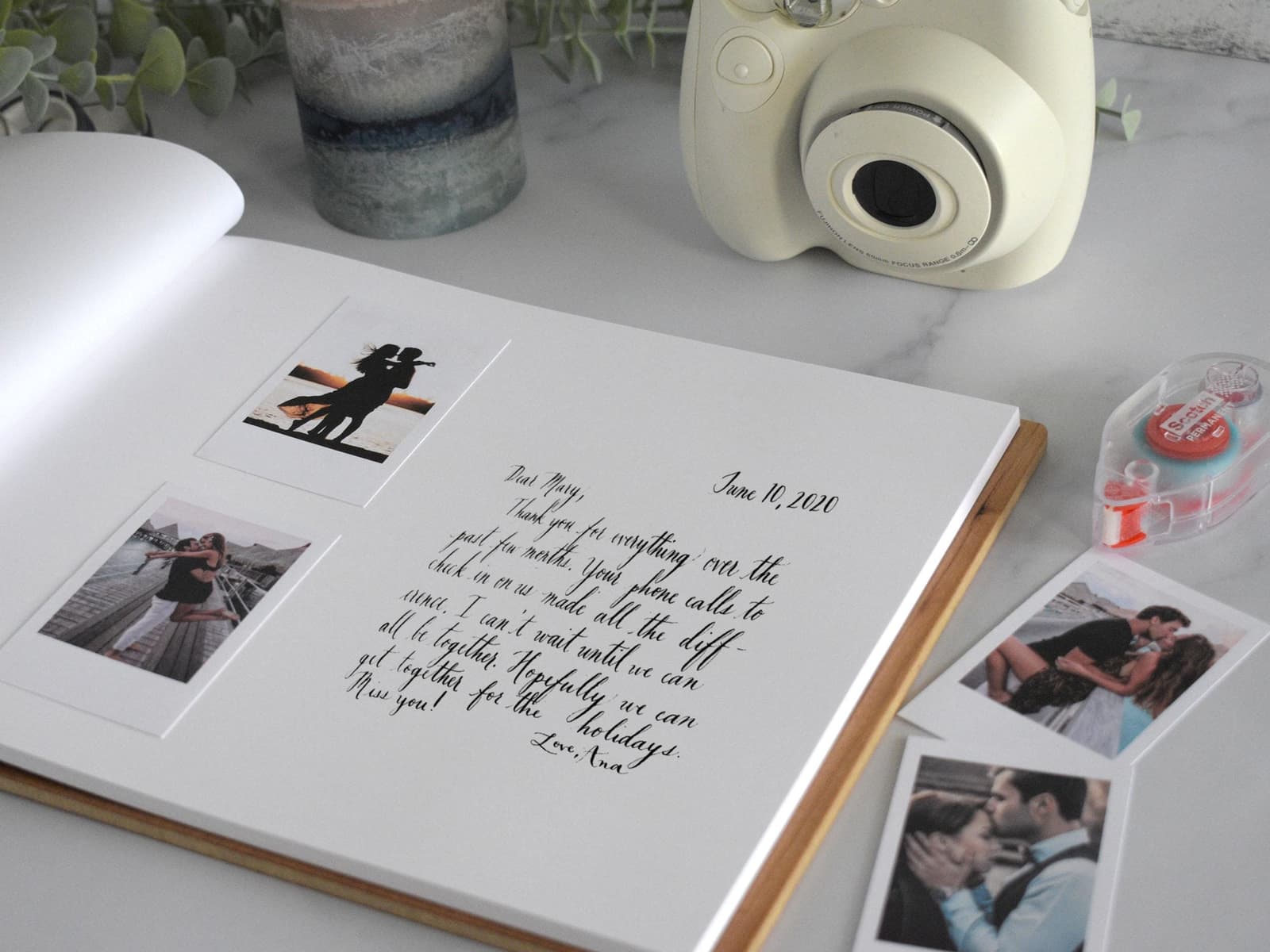 a photo book with photos and a camera on a table