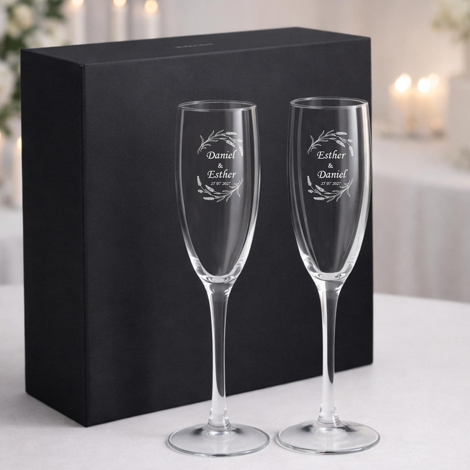 Dos copas de cava grabadas con los nombres de la pareja, dentro de un estuche negro abierto