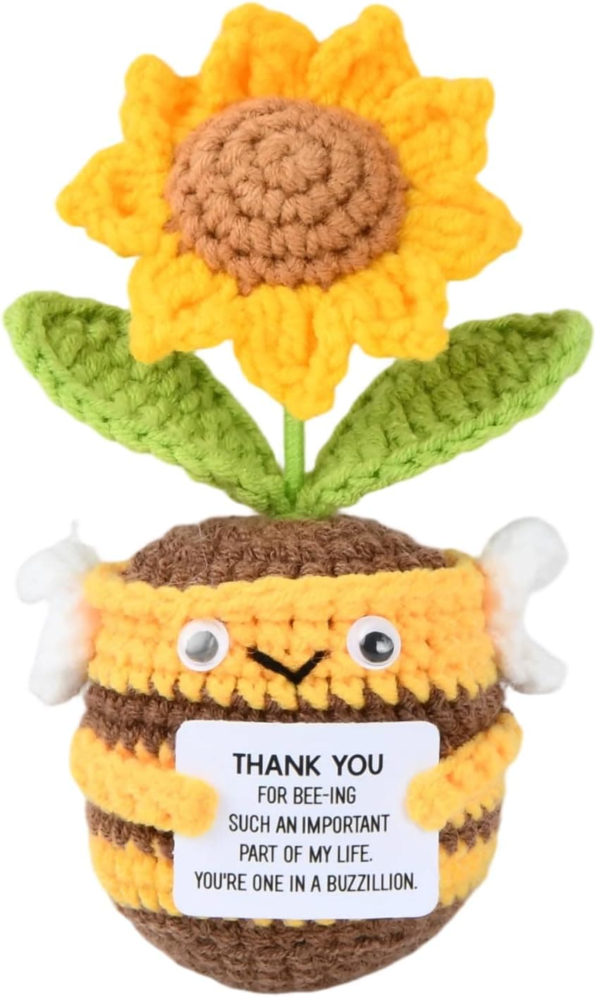 Abeja de ganchillo amarilla y marrón con un girasol saliendo de su cabeza, sujetando una tarjeta de agradecimiento