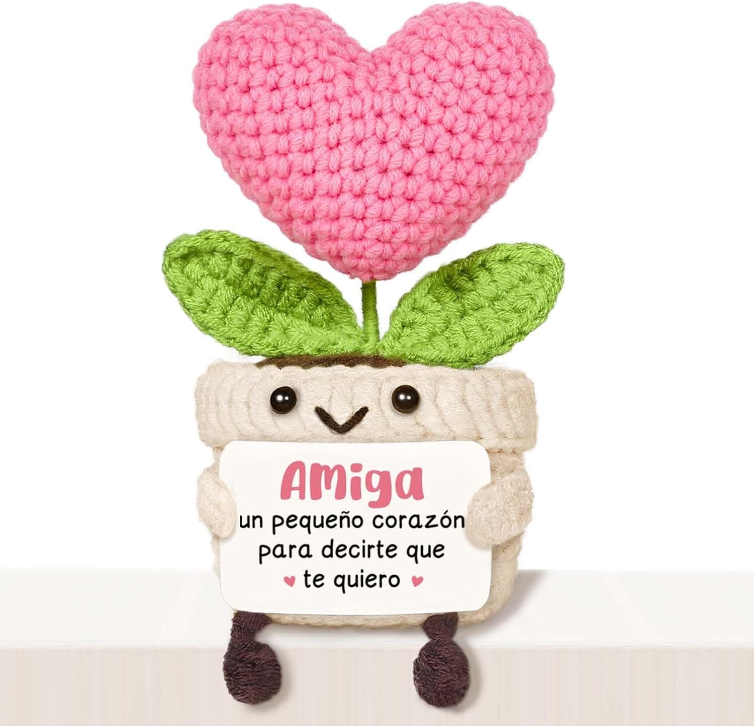 Corazón rosa de ganchillo en maceta con carita, sujetando un cartel que dice Amiga, un pequeño corazón para decirte que te quiero