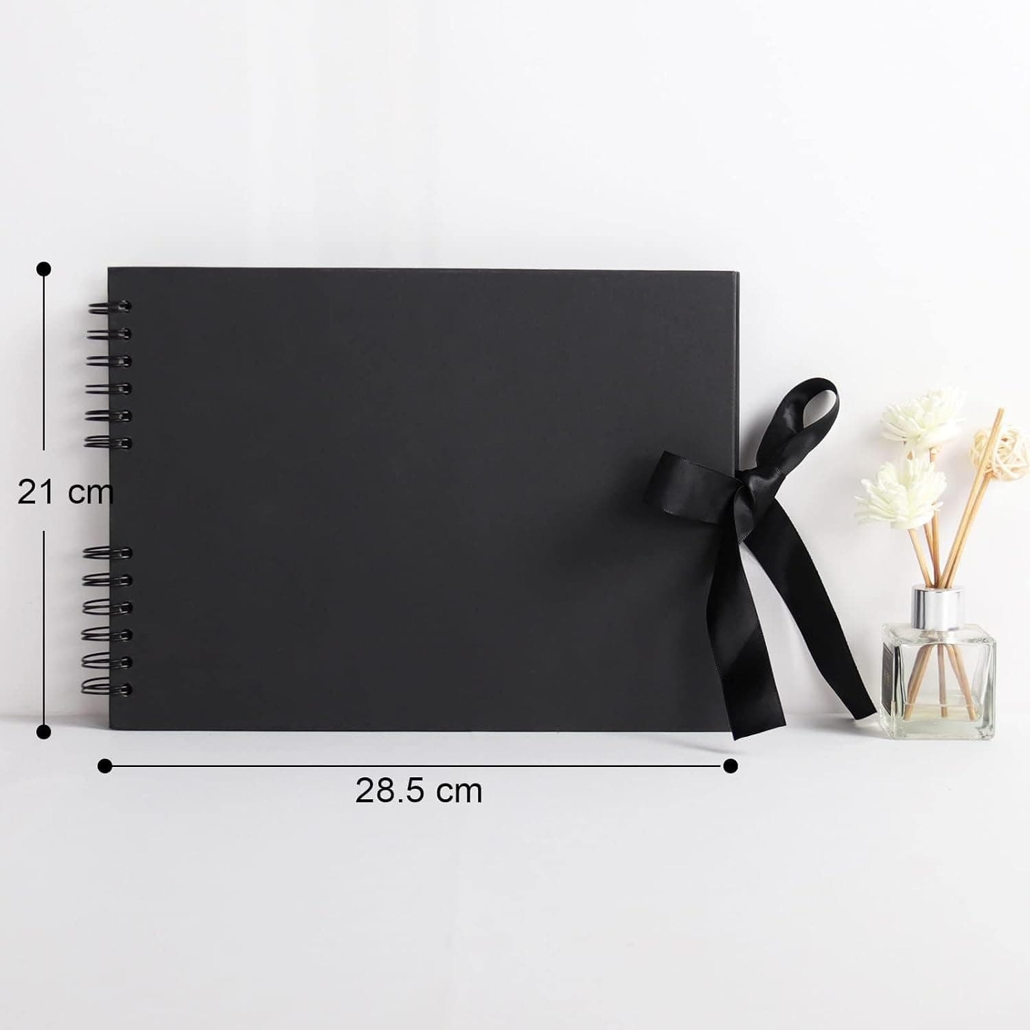El álbum abierto sobre una mesa, con dos fotos pegadas y la fecha rotulada a mano en dorado junto a una cámara antigua