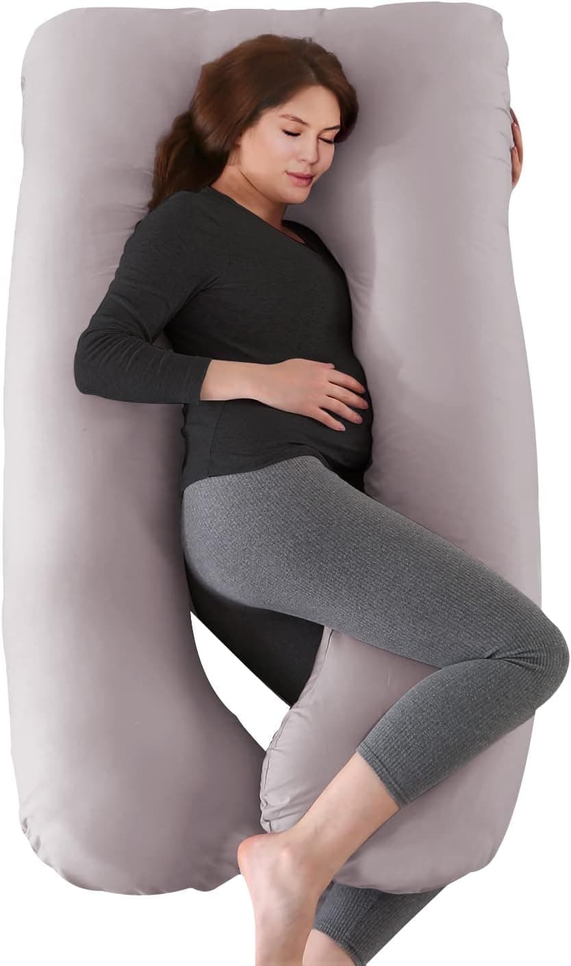 Mujer embarazada durmiendo de lado abrazada a una almohada gris en forma de U que le rodea el cuerpo