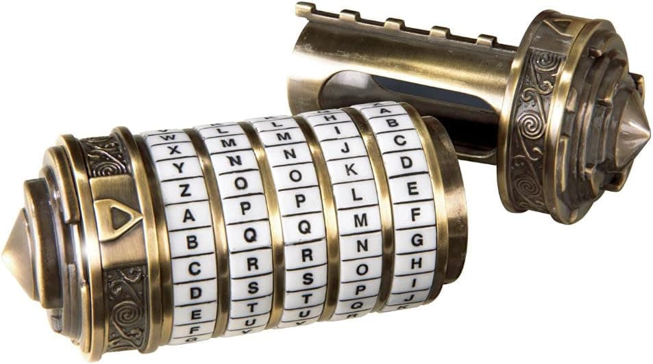 Cryptex de metal dorado y patinado, desmontado en sus dos mitades sobre fondo blanco