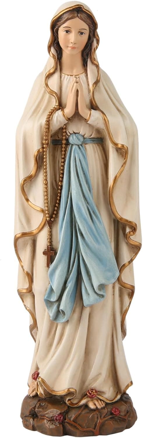 La figura entera de la Virgen de Lourdes, con manto crema ribeteado en oro, faja azul y el rosario colgando de las manos juntas