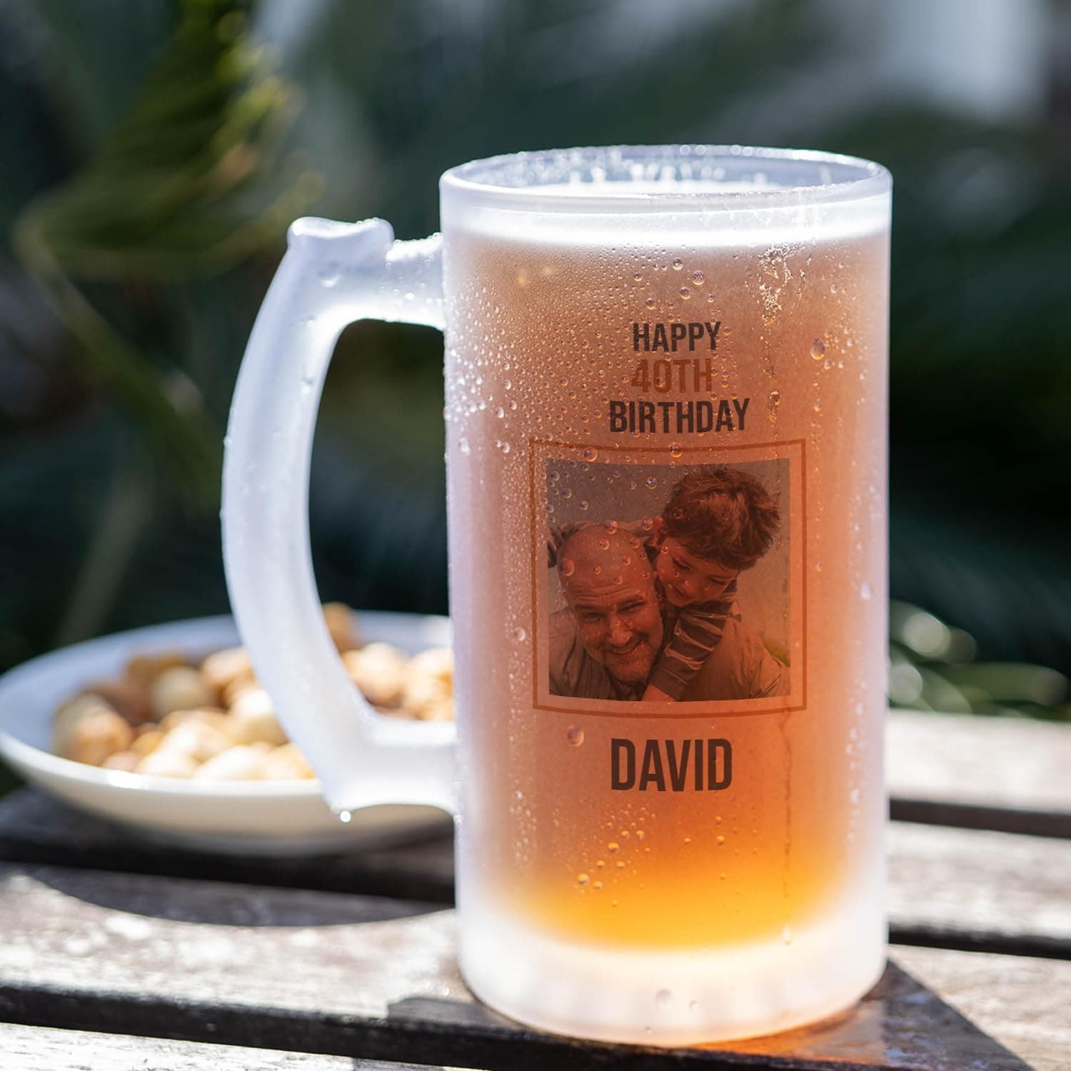 Jarra de cristal esmerilado con una foto grabada de un abuelo con su nieto, el texto de felicitación de cumpleaños y el nombre «David» debajo, servida con cerveza fría
