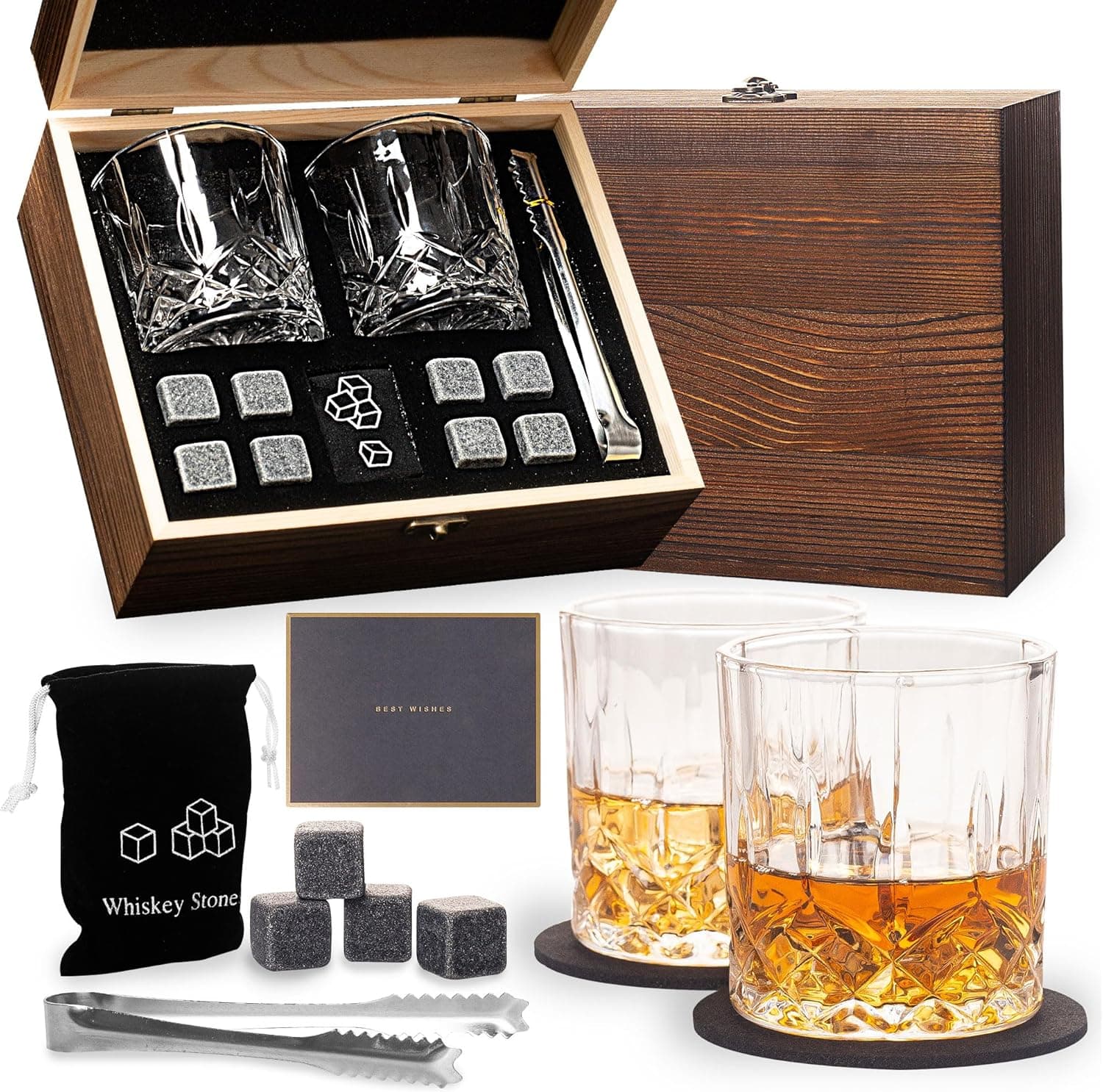 Caja de madera abierta con dos vasos de whisky tallados, ocho piedras de granito, unas pinzas y una bolsa de terciopelo, junto a los vasos servidos con whisky y hielo de piedra