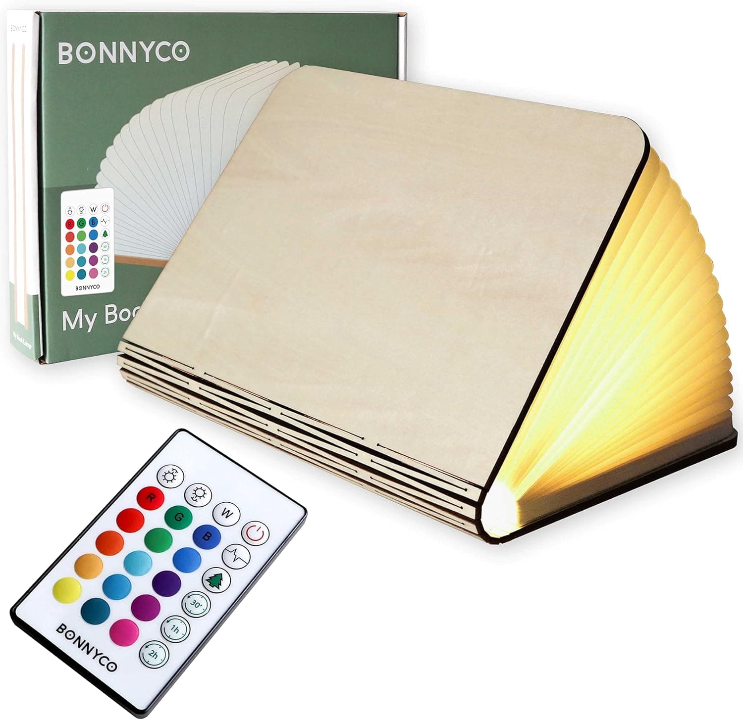 La lámpara con forma de libro de madera de arce abierta y encendida junto a su mando a distancia, con la caja del producto detrás