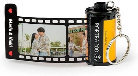 Llavero con forma de carrete de fotos analógico junto a una tira desplegable con dos fotografías de una pareja y el texto "María & Iñaki"