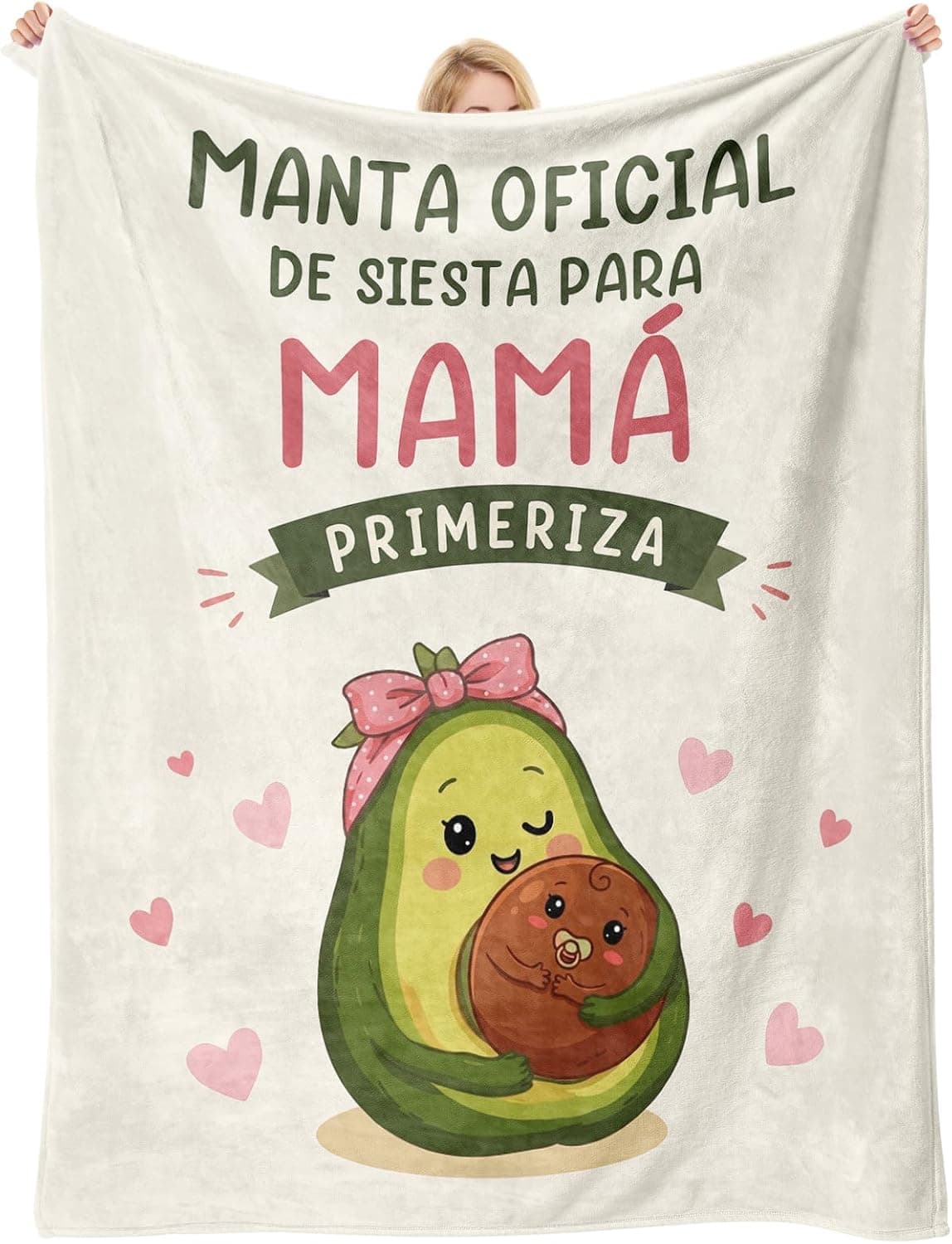 Manta beige desplegada con un aguacate ilustrado abrazando a su hueso-bebé y el texto «manta oficial de siesta para mamá primeriza»