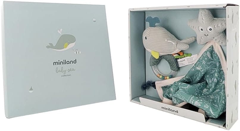 La caja abierta con el sonajero de ballena y el doudou de estrella de mar sobre el pañuelo verde estampado
