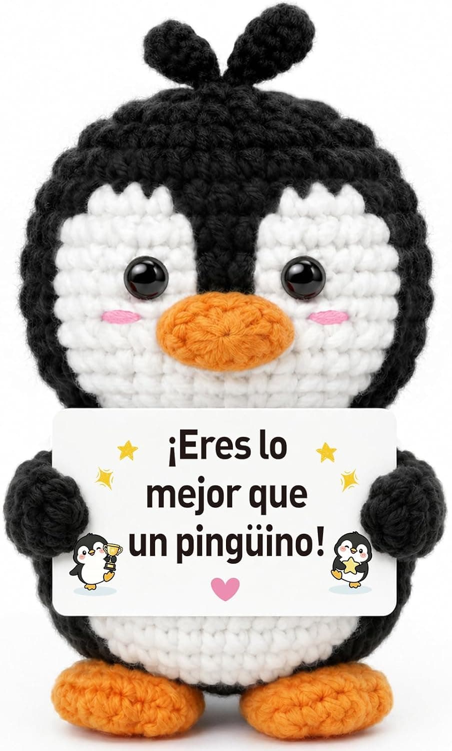 Pingüino de ganchillo negro y blanco con mejillas rosas, sosteniendo una tarjeta con el mensaje y estrellas doradas