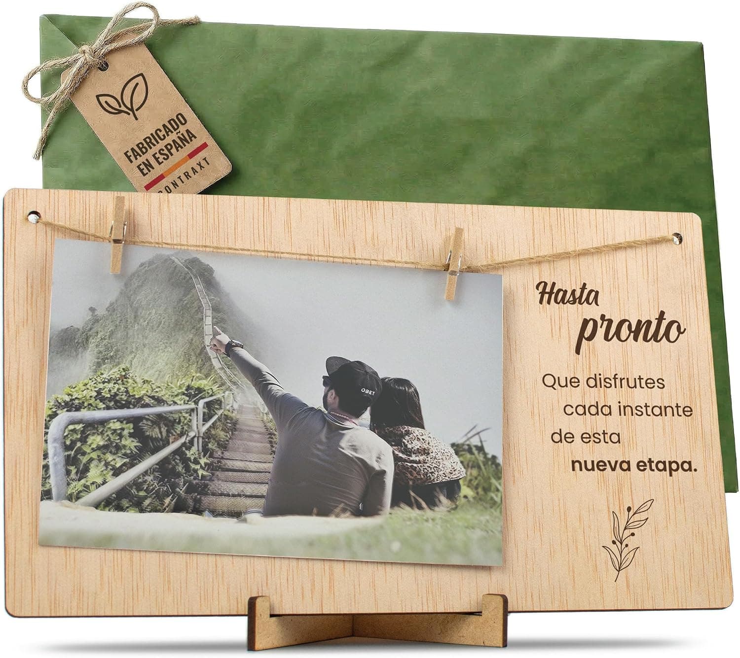 Tabla de madera clara con una foto sujeta por pinzas y el texto «Hasta pronto» grabado al lado, con su sobre verde y la etiqueta de regalo