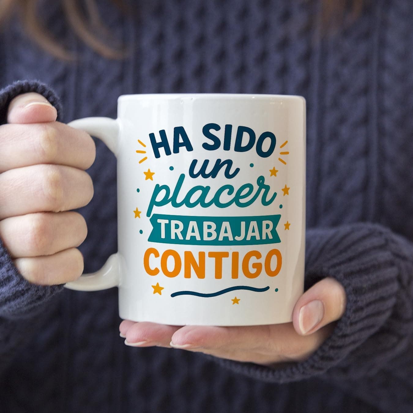 Taza blanca de frente con la frase «Ha sido un placer trabajar contigo» en azul, verde y naranja, con estrellas y una raya ondulada debajo