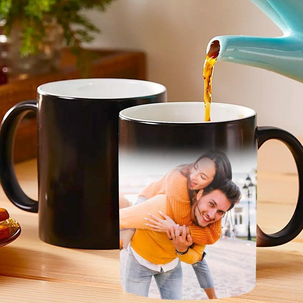Dos tazas negras, una vacía y otra con té sirviéndose dentro mostrando ya la foto de una pareja revelada por el calor
