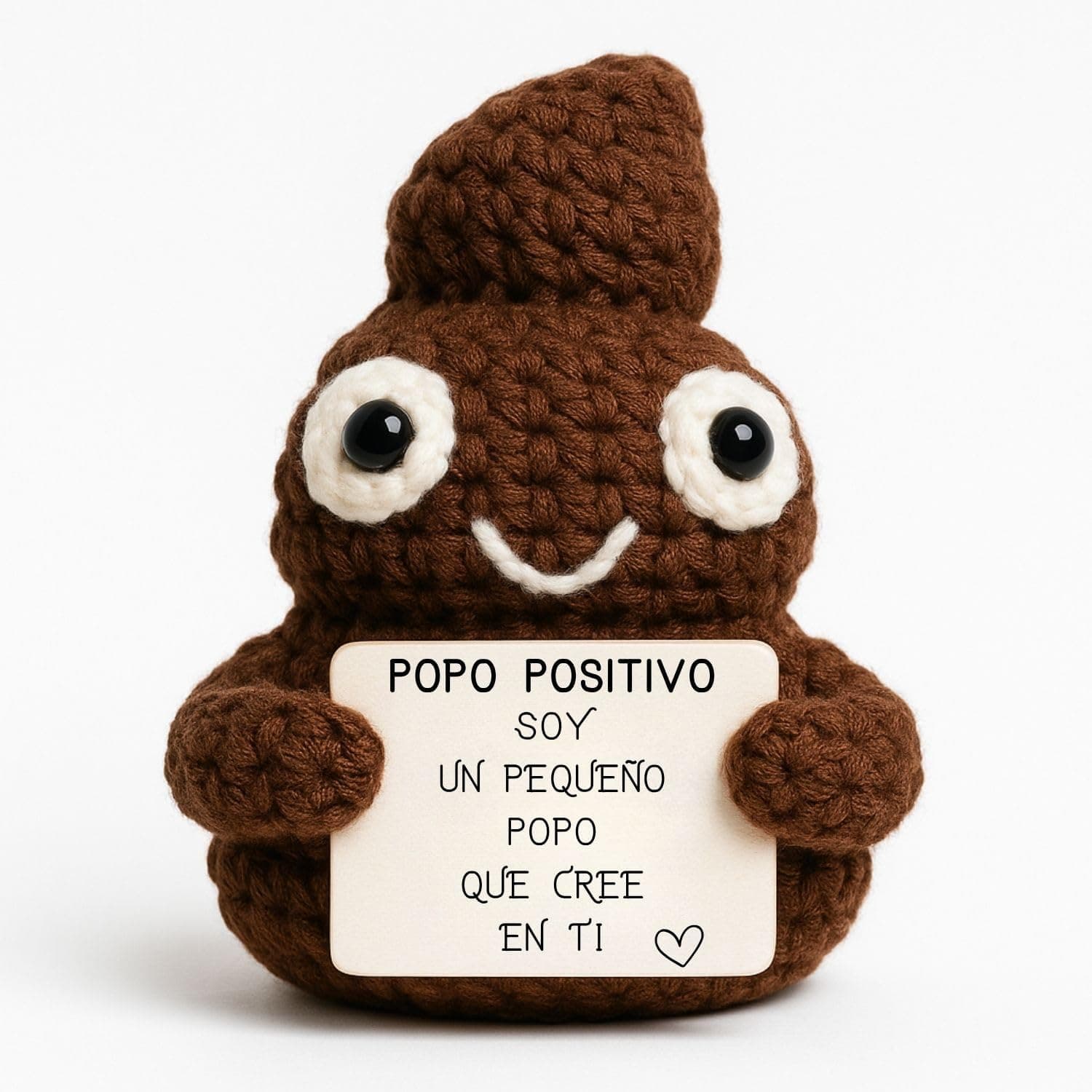 Peluche tejido a ganchillo con forma de caca sonriente, sujetando un cartel que dice Popó Positivo